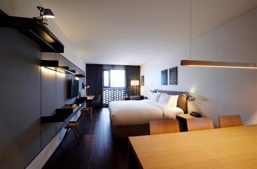 a hotel room with a bed and a table and chairs at GLAD Yeouido in Seoul