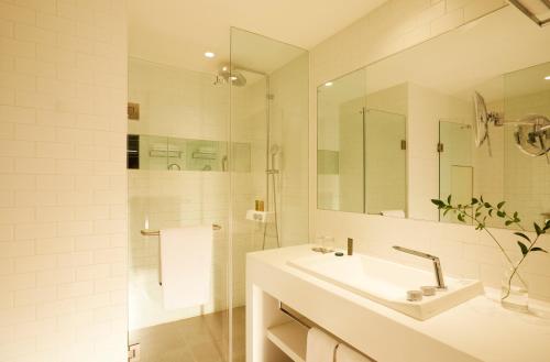a white bathroom with a sink and a mirror at GLAD Yeouido in Seoul