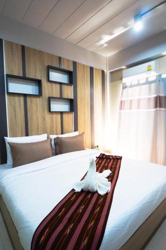 a large bed with a white bird sitting on it at Supreme Place SHA Plus in Khon Kaen