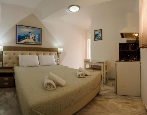 a bedroom with a bed with two towels on it at Kanali Studios in Parga