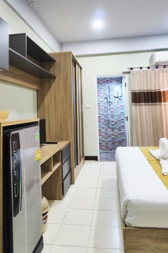 a small kitchen with a refrigerator and a shower at Supreme Place SHA Plus in Khon Kaen