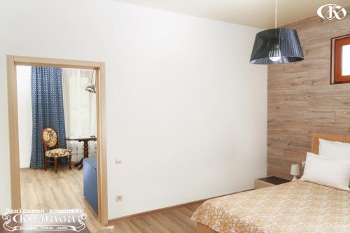 a bedroom with a bed and a mirror and a chair at Hotel Complex Kupava in Podvorki