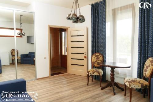 a living room with a table and chairs and a mirror at Hotel Complex Kupava in Podvorki