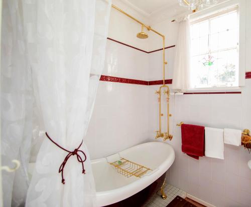 a white bathroom with a tub and a window at Ella's Place in Broken Hill