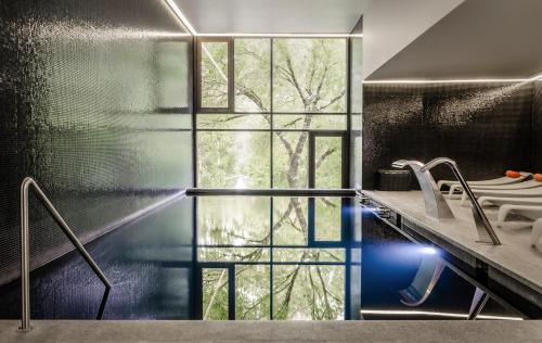 a bathroom with a large window and a sink at Aqua Village, Health Resort in Oliveira do Hospital