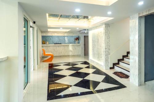a lobby with a black and white checkered floor at Supreme Place SHA Plus in Khon Kaen