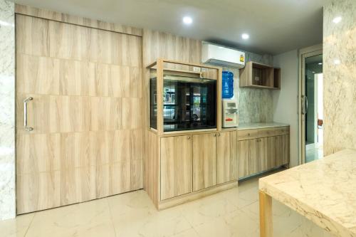 a kitchen with wooden cabinets and a counter at Supreme Place SHA Plus in Khon Kaen