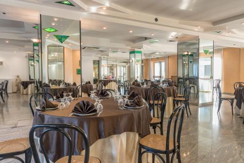 un salón de banquetes con mesas, sillas y espejos en Albergo Carpino, en Mangone