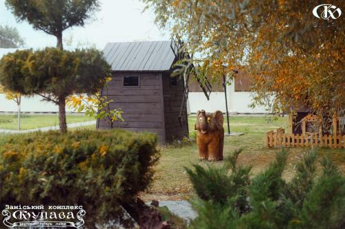 a statue of a bear standing in a yard at Hotel Complex Kupava in Podvorki