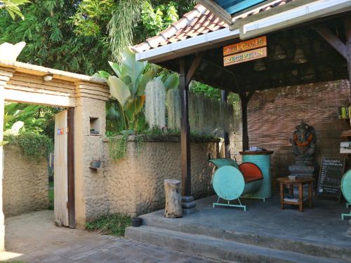 an outdoor area with a building with a sign at Louto Dmell Villa & Guesthouse in Sanur