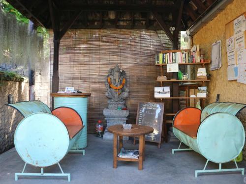a room with two chairs and a table and a statue at Louto Dmell Villa & Guesthouse in Sanur
