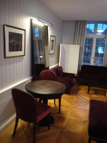 a living room with a table and chairs at Logis Hôtel Ettenheim in Strasbourg