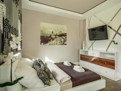 a bedroom with a bed and a tv on a wall at TatryTop Zakopiańskie Tarasy Premium & SPA in Zakopane