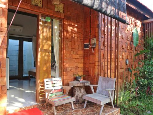two chairs and a table in front of a building at Louto Dmell Villa & Guesthouse in Sanur
