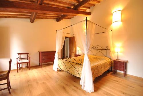 サン・ジミニャーノにあるVilla Margheのベッドルーム(天蓋付きベッド1台付)