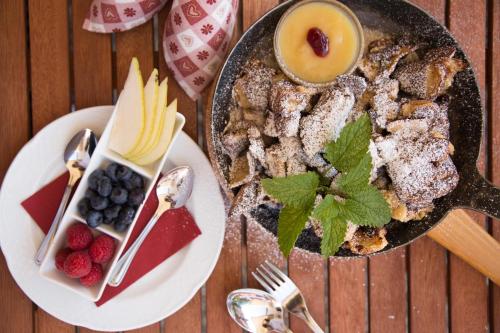 a table topped with a plate of food with fruit at Bergidyll & Hotel Trofana in Leutasch