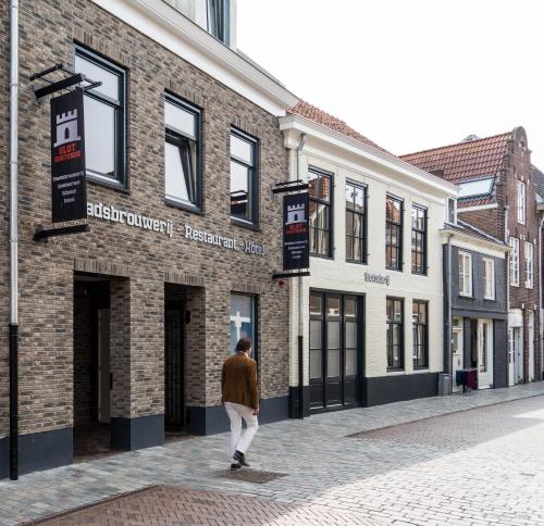 a man walking in front of a brick building at Slot Oostende in Goes