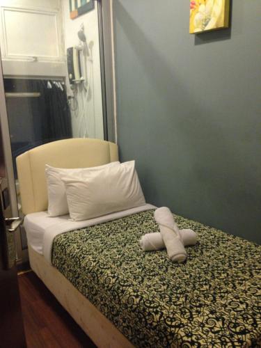 a bedroom with a bed with a stuffed animal on it at Woodpecker Lodge, Kuching in Kuching