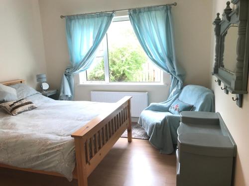 a bedroom with a bed and a window and a chair at Ballydevitt Retreat in Donegal
