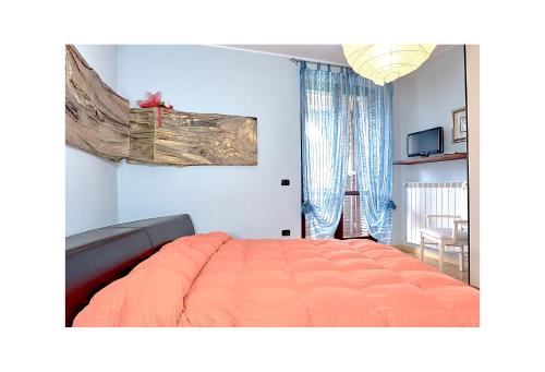 a bedroom with a large orange bed and a window at Villa valtopina in Valtopina