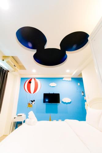a bedroom with a blue wall with a bat ceiling at Lè mù in Taichung