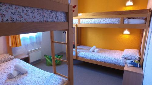 two bunk beds in a small room with a room with another bed at VVF La Plagne Montchavin Paradiski in Bellentre