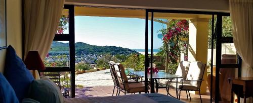 a room with a balcony with a table and chairs at Panorama Guest House in Port Alfred