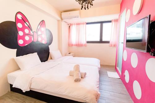 a room with two beds with a teddy bear on it at Lè mù in Taichung