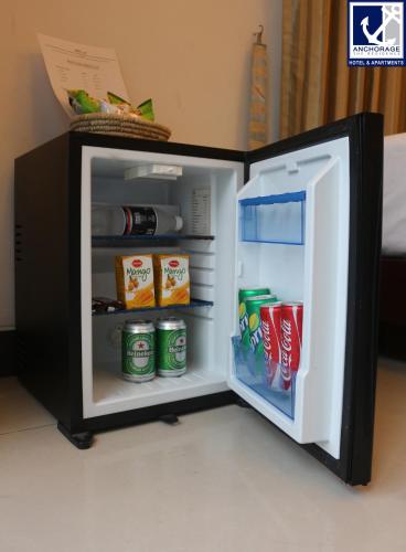 an open refrigerator with drinks inside of it at Anchorage The Residence in Dhaka