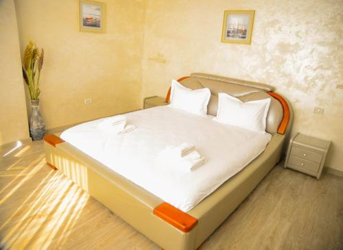 a bed with white sheets and pillows in a room at La Marcu Pensiune in Tulcea
