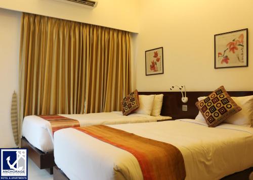 two beds in a hotel room with curtains at Anchorage The Residence in Dhaka