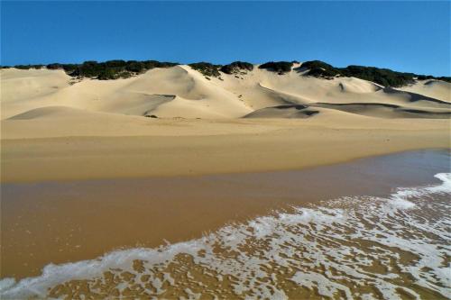 a group of sand dunes with a body of water at Panorama Guest House in Port Alfred