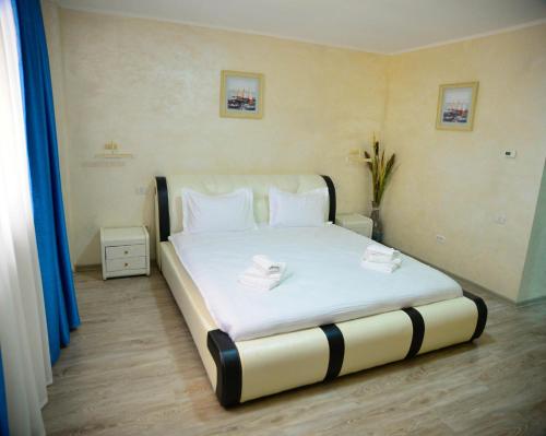 a bedroom with a bed with two towels on it at La Marcu Pensiune in Tulcea