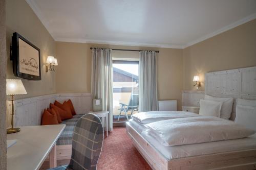 um quarto de hotel com uma cama e um sofá em MEIN WURMKOGEL - IHR WOHLFÜHLHOTEL boutique superior em Hochgurgl