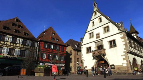 a group of buildings in a city with a tower at VVF Plaine d'Alsace Obernai Strasbourg in Obernai