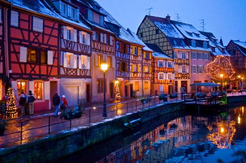 a group of buildings next to a river in a city at VVF Alsace Orbey Colmar in Orbey