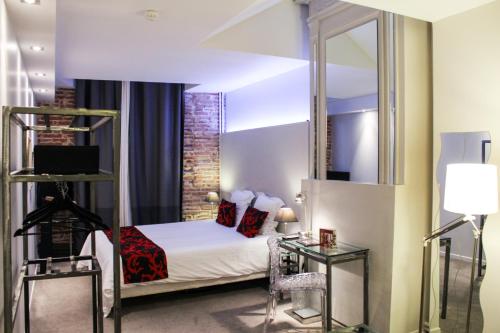 a hotel room with a bed and a mirror at Hôtel des Arts in Toulouse