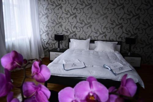 a bedroom with a bed with purple flowers in the foreground at Villa Romeo in Brzeg