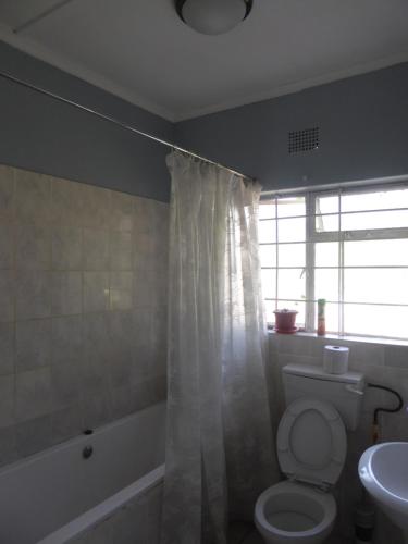 a bathroom with a toilet and a tub and a sink at Natwange Backpackers in Lusaka