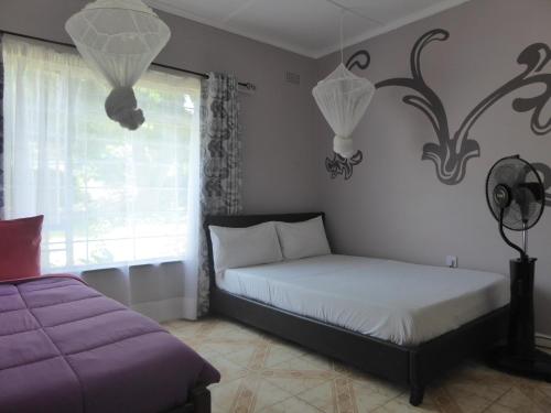 a bedroom with two beds and a window at Natwange Backpackers in Lusaka