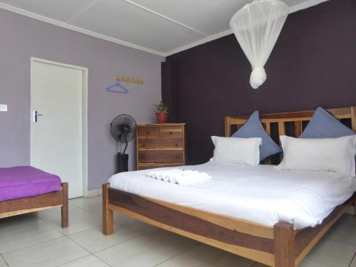 1 dormitorio con 1 cama con almohadas azules y blancas en Natwange Backpackers, en Lusaka