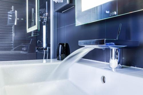 a bathroom with a bath tub with a sink at Maison Albar - Le Diamond in Paris