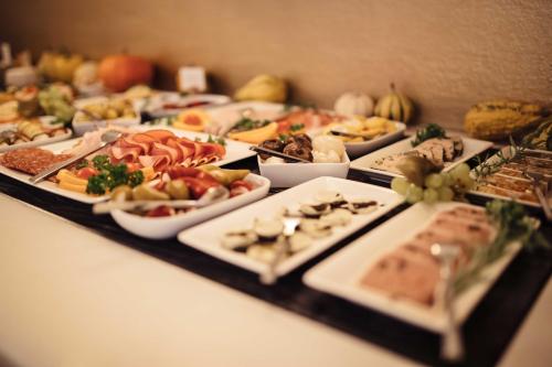 a table filled with different types of food on plates at Hotel Rathaus - Wein & Design in Vienna