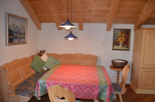 sypialnia z łóżkiem i drewnianym sufitem w obiekcie Haus Enzian w mieście Seefeld in Tirol