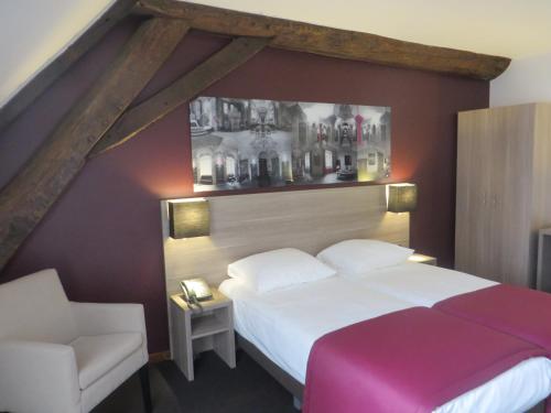 a bedroom with a white bed and a chair at Abdij Hotel Rolduc in Kerkrade