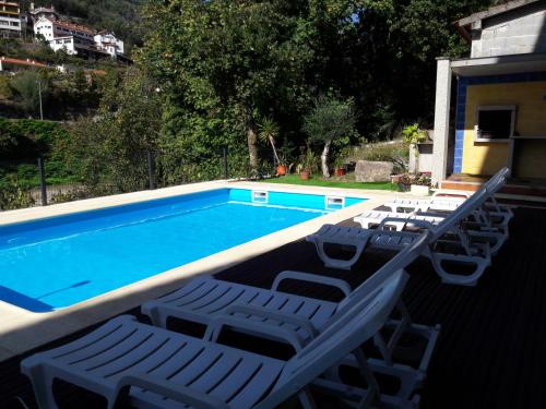a group of lounge chairs and a swimming pool at Casa Ribom in Geres