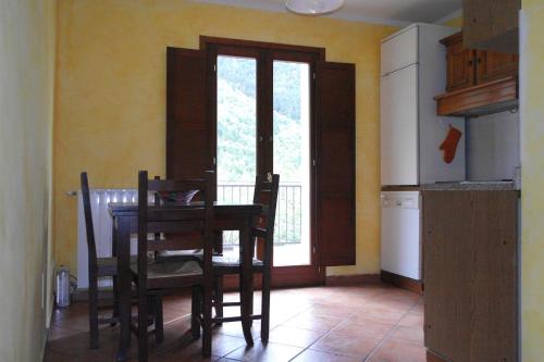 eine Küche mit einem Tisch und Stühlen sowie einem Fenster in der Unterkunft Casa Vacanze sul Gizio in Pettorano sul Gizio