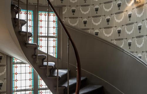 a winding staircase with a patterned wall at Hôtel Mansart - Esprit de France in Paris