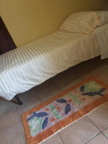 a bed with a rug on the floor next to a room at B & B La Guesthouse in Poirino