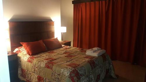 Un dormitorio con una cama con una colcha encima en Barrio Privado Los Sauces, en San Juan